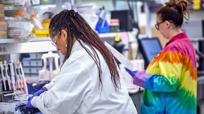 two women in lab with rainbow coat